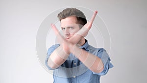 European young man shows a stop sign with his hands