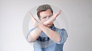 European young man shows a stop sign with his hands