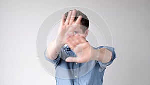 European young man shows a stop sign with his hands