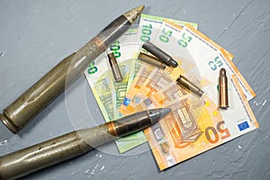 Euros money, bullets, shells, cartridges and projectiles on gray background. Lend-Lease concept.  Army concept. Sales of weapons