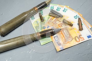 Euros money, bullets, shells, cartridges and projectiles on gray background. Lend-Lease concept.  Army concept. Sales of weapons