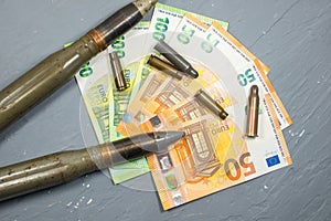 Euros money, bullets, shells, cartridges and projectiles on gray background. Lend-Lease concept.  Army concept. Sales of weapons