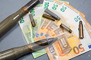 Euros money, bullets, shells, cartridges and projectiles on gray background. Lend-Lease concept.  Army concept. Sales of weapons