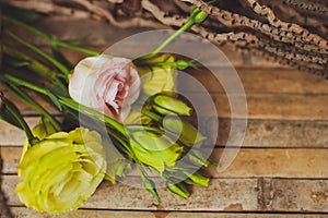 Eustoma and rose lying on a wooden board