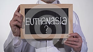 Euthanasia question on blackboard in therapist hands, life or death decision
