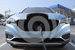 EV Car alternative fuel charging plugged at quick charge station.