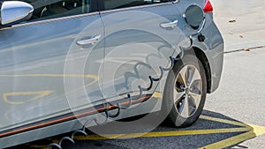 EV Car or Electric car at charging station with the power cable supply plugged in. Eco-friendly alternative energy concept