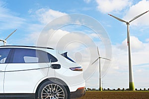 EV Car or Electric car at charging station with the power cable supply plugged on eoliene in background