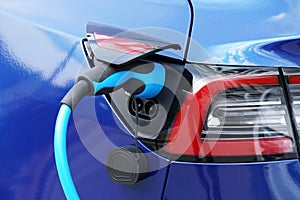 EV or Electric car at charging station with plug-in power supply cable photo