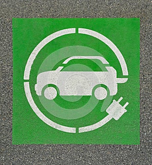 EV - electric vehicle charging station sign on asphalt. `E` sign on asphalt background