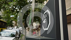 EV electric vehicle sign with plug image at city street car parking lot.