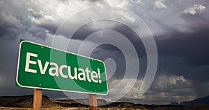 Evacuate Green Road Sign and Stormy Clouds photo
