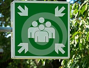 Evacuation assembly point sign in green and white. Gathering point board to lead people to a safe place during an emergency.