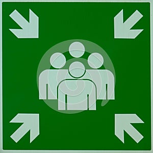 Evacuation assembly point sign in green and white. Gathering point board to lead people to a safe place during an emergency.