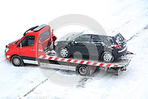 Evacuation of a broken car in cold winter. In winter, a tow truck takes the car away after an accident. Car assistance in winter