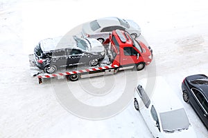 Evacuation of a broken car in cold winter. In winter, a tow truck takes the car away after an accident. Car assistance in winter