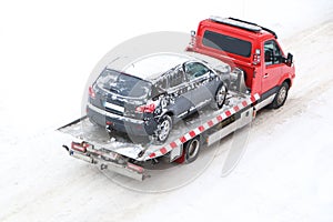 Evacuation of a broken car in cold winter. In winter, a tow truck takes the car away after an accident. Car assistance in winter