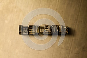 EVALUATED - close-up of grungy vintage typeset word on metal backdrop photo