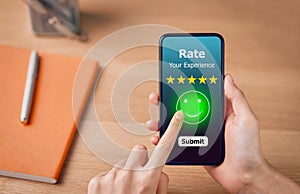Evaluation and rating concept, woman pressing happy smile face emoticon and 5 star rating or review on smartphone.
