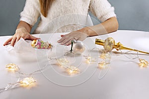 On the eve of Christmas. Young woman sitting at table in near fairy lights