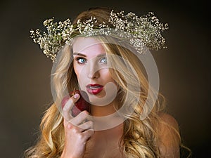 Eve and that fateful apple. Studio shot of a gorgeous young woman eating a red apple against a dark background.