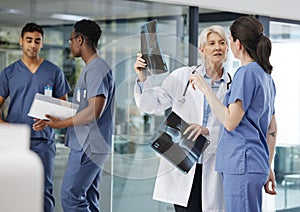 Even the best doctors need help. two female doctors examining an x-ray at a modern hospital.