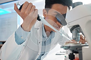 Even the slightest twitch could be a problem. Shot of a male lab tech filling a petri dish underneath a microscope.