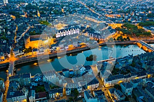 Evening aerial view of Laval with buildings, river Mayenne and old bridge photo
