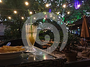 The evening in a cafe among powerful trees