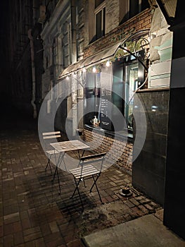 An evening cafe with a table and chairs outside on the first floor of the building