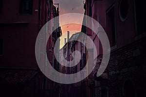 Evening canal scene at sunset, Venice, Italy. Romantic dark and vibrant cityscape