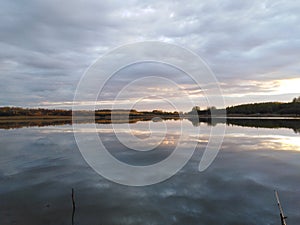 The evening cloudy sky is reflected in the lake.