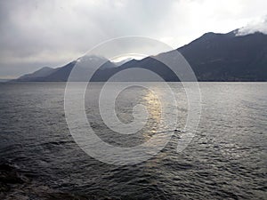 Cold dark sea with mountains in the background and low clouds. Northern inhospitable seascape photo