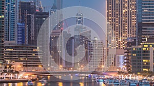Evening Dubai marina city centre with floating vessels day to night timelapse