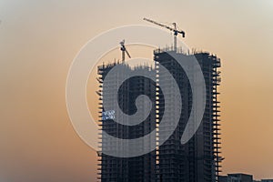 Evening dusk shot of Trump Towers under construction building skyscraper in gurgaon showing rapid growth of