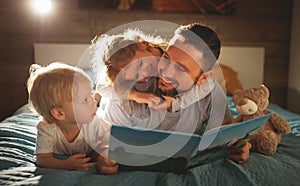 evening family reading. father reads children . book before going to bed .