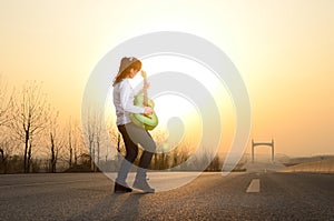 In the evening, girl playing guitar on the road