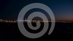 Evening golden blurred lights of the bridge near the river. Concept. Big city bokeh bridge lights out of focus on a