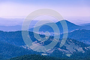 Evening haze over forested hills and mountains.