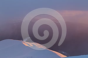 Evening high alpine winter scenery, with fresh snow and mist, in the Alps