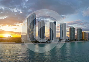 Evening landscape of sandy beachfront in Sunny Isles Beach city with luxurious highrise hotels and condo buildings on