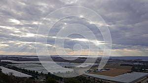 Evening landscape view on Mediterranean Sea coastline, sky, clouds, valley with water reservoir and orangeries