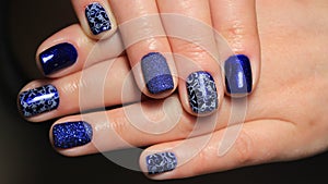 Evening manicure, design cold colors, blue gel polish with silver ribbons and pattern