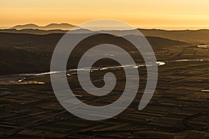 Evening mood panorama taken from Byllis village - Aerial view of landscape with fields, river band and mountains in the background photo
