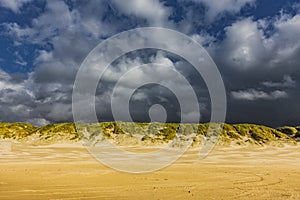 Evening mood with stromy clouds in dune landscape photo