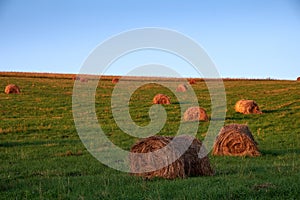 Evening over farm field with hay bales