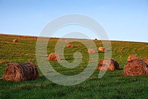 Evening over farm field with hay bales