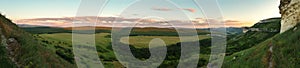 Evening panorama of the green valley. View from the top of cave city Bakla in Crimea.