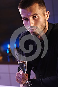 Evening portrait of young man with champagne flute