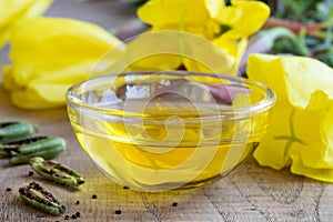 Evening primrose oil in a bowl, with fresh evening primrose flow